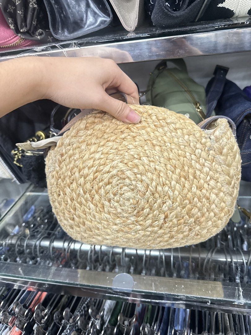 Round Straw Crossbody Bag with Seashells (Category: Cross-body Bags) located in Abucay. Submitted by fastlion.584bdf (Listing ID 1470649053, Image 3). Description: - Style: Round woven straw crossbody bag - Details: White seashell flower motifs on the front - Features: Tan leatherette strap attachments and secure zipper closure - Size: Compact, perfect for summer outfits and beach days - Condition: Clean inside and out, ready to use.