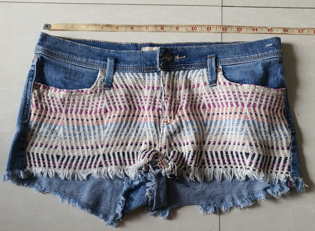 Roxy Denim Boho Woven Front Panel Cutoff Shorts (Category: Shorts) located in Meycauayan. Submitted by shoptoown (Listing ID 1470573839, Image 2). Description: - Brand: Roxy - Size: 7/28 - Style: Denim cutoff shorts with raw fringe hems and classic 5-pocket design - Details: Unique multicolored woven boho pattern panel on the front, button fly - Wash: Blue wash denim - Condition: Great festival-ready piece!.