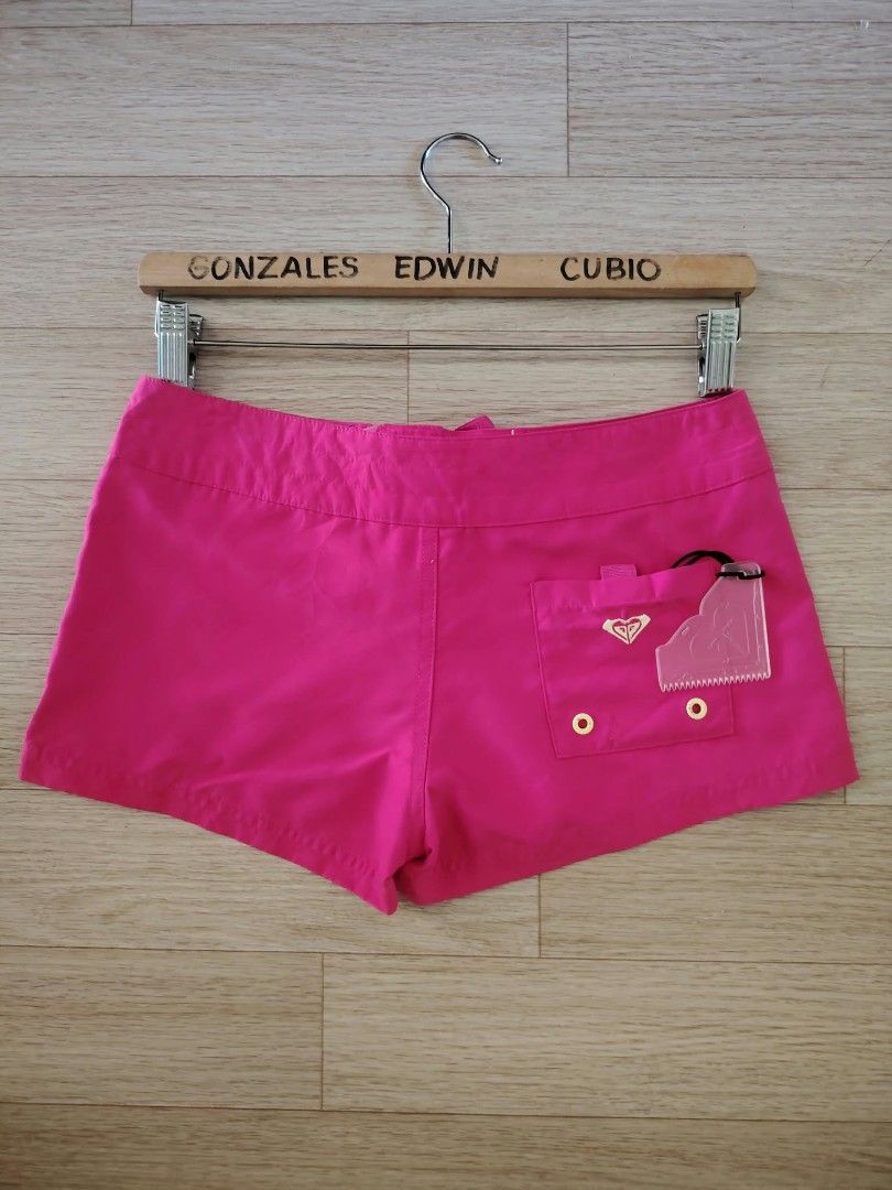 Roxy Pink Board Shorts Size 26 (Category: Bikinis & Swimsuits) located in Nasipit. Submitted by edwingonzales498-69377 (Listing ID 1470615574, Image 3). Description: - Brand: Roxy - Color: Bright pink - Size: 26 (68cm waist) - Features: Lace-up drawstring waist, back pocket with original wax comb included inside - Condition: Vibrant color, perfect for surfing and beach days - Note: Exact measurements are shown in the photos.