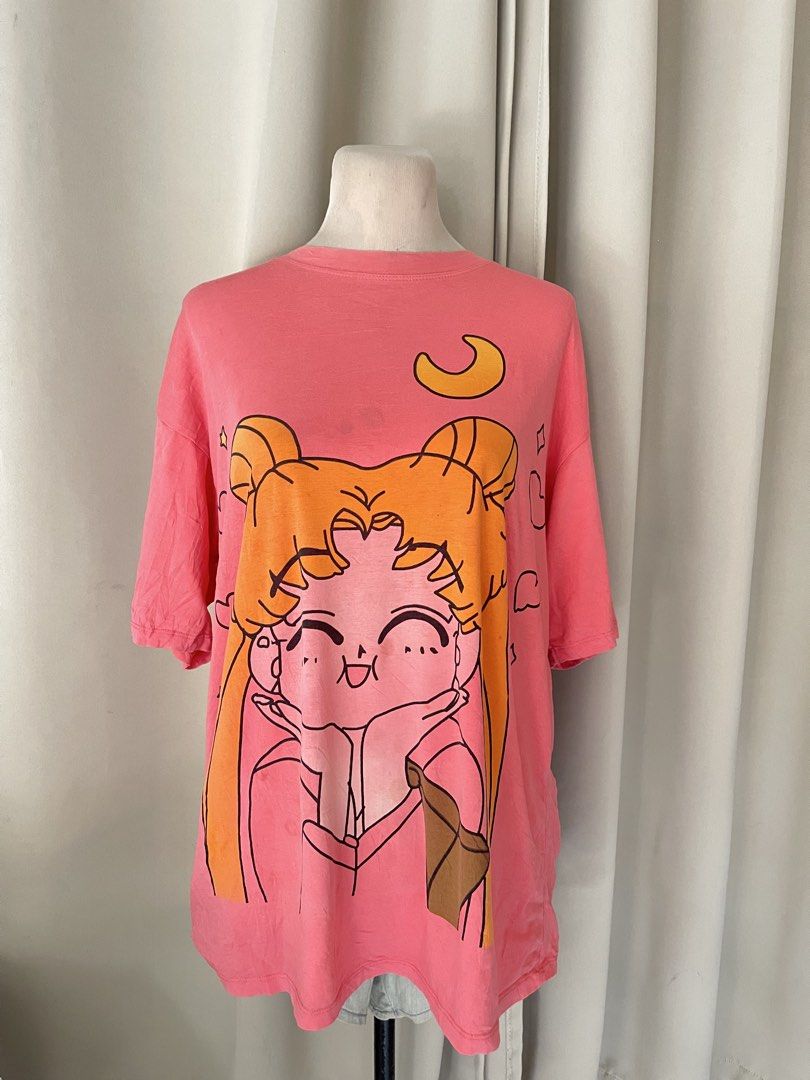 Sailor Moon Pink Oversized Graphic T-Shirt (Category: Shirts) located in Cainta. Submitted by zlove111 (Listing ID 1470707618, Image 1). Description: - Color: Bright pink - Design: Chibi Sailor Moon graphic with yellow crescent moon - Fit: Oversized / relaxed fit - Style: Short sleeves, crew neckline - Flaw: Small faint smudge near the collar between the hair buns (check close-up photo) cute. selling low, may dirt:light stain. no other issue up t