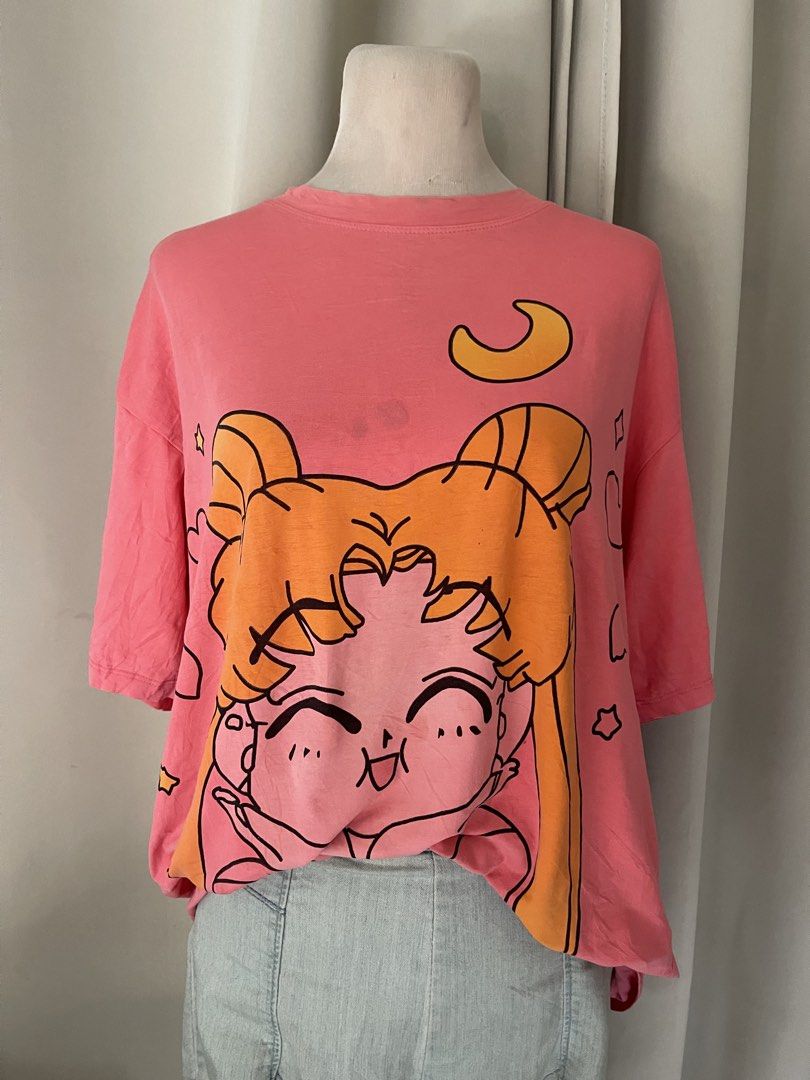 Sailor Moon Pink Oversized Graphic T-Shirt (Category: Shirts) located in Cainta. Submitted by zlove111 (Listing ID 1470707618, Image 2). Description: - Color: Bright pink - Design: Chibi Sailor Moon graphic with yellow crescent moon - Fit: Oversized / relaxed fit - Style: Short sleeves, crew neckline - Flaw: Small faint smudge near the collar between the hair buns (check close-up photo) cute. selling low, may dirt:light stain. no other issue up t