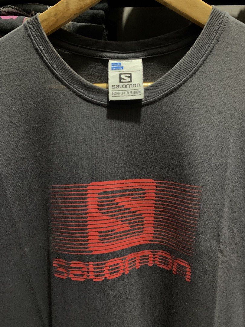 Salomon Graphic Tee Dark Grey Size L (Category: Tshirts & Polo Shirts ) located in Manila. Submitted by consencino97571 (Listing ID 1470712366, Image 1). Description: - Brand: Salomon - Color: Dark grey with bold red striped chest logo - Size: Large (tag on collar) - Material: Soft cotton, regular fit - Origin: Made in Tunisia - Condition: Clean piece with print completely intact.