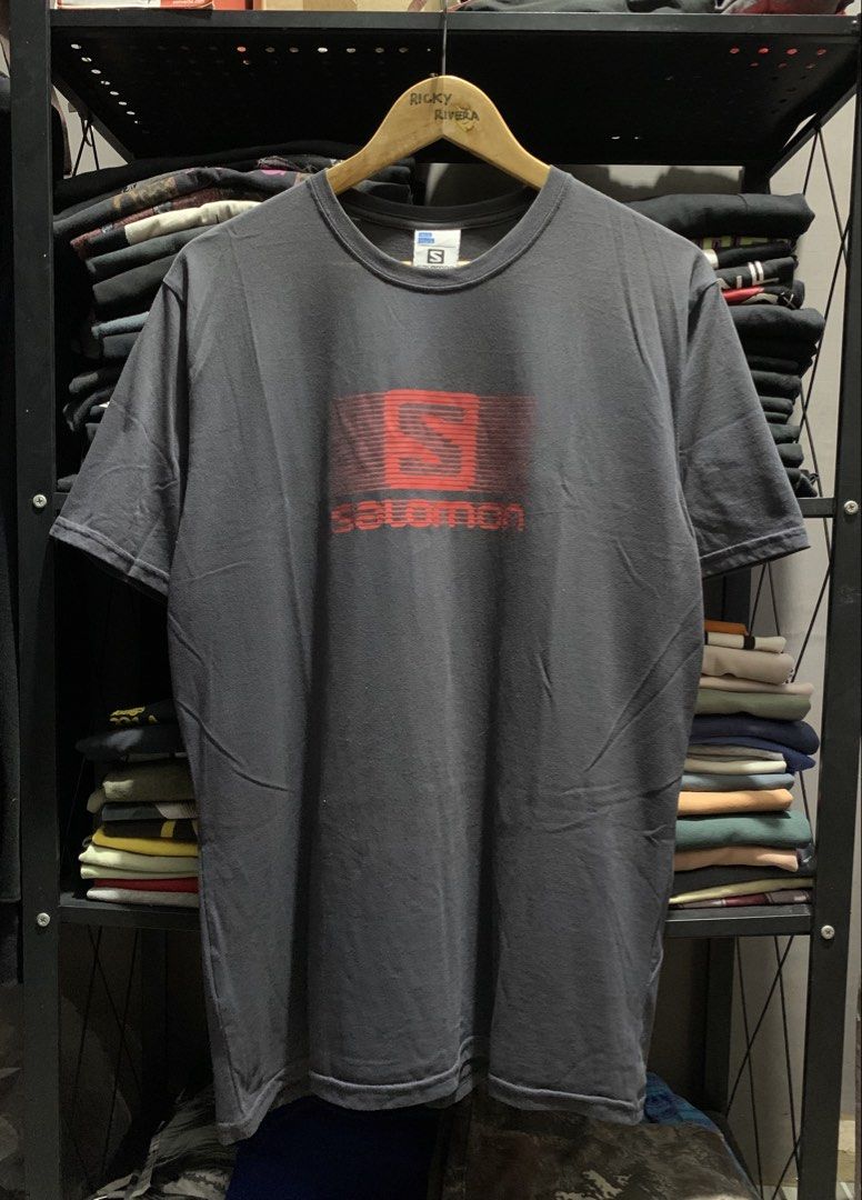 Salomon Graphic Tee Dark Grey Size L (Category: Tshirts & Polo Shirts ) located in Manila. Submitted by consencino97571 (Listing ID 1470712366, Image 2). Description: - Brand: Salomon - Color: Dark grey with bold red striped chest logo - Size: Large (tag on collar) - Material: Soft cotton, regular fit - Origin: Made in Tunisia - Condition: Clean piece with print completely intact.