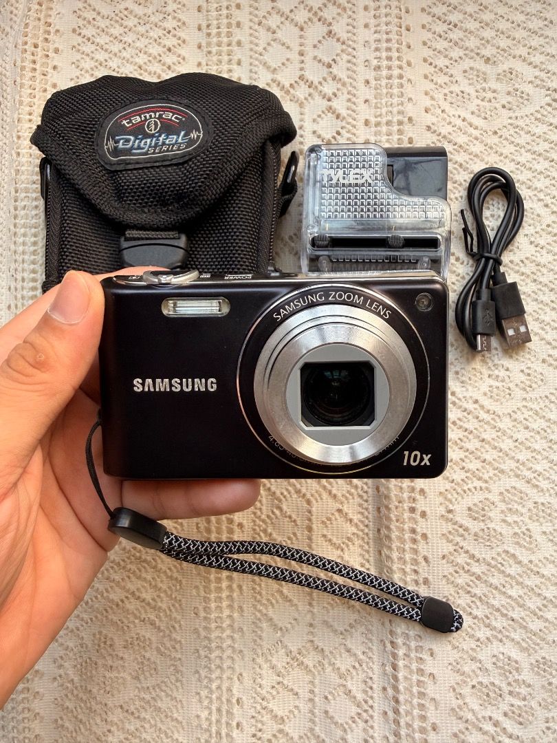 Samsung PL211 10x Zoom Digital Camera Bundle (Category: Cameras) located in Dagupan City. Submitted by digicambyharley_jmnz404 (Listing ID 1470629044, Image 1). Description: - Model: Samsung PL211 Digital Camera (Black) - Resolution: 14 Megapixels with 10x Optical Zoom - Condition: Tested, powers on, and screen is clear - Includes: Tamrac padded camera bag, battery charger, and USB cable, SD card - Extras: Wrist strap attached - Perfect for: Casu