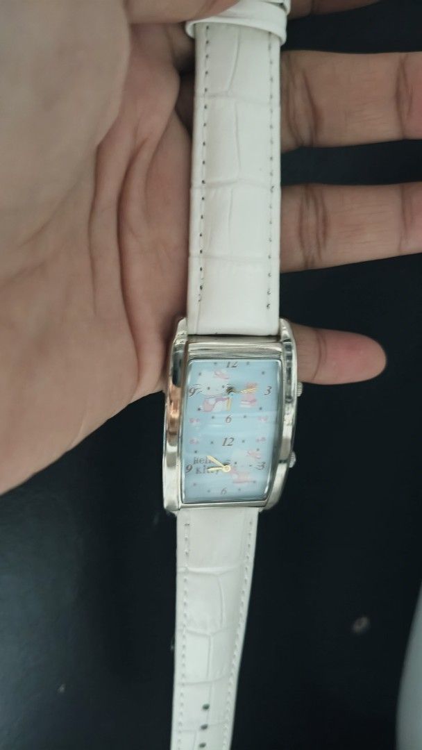 Sanrio Hello Kitty Dual Time Rectangular Watch (Category: Women's Watches) located in Taguig. Submitted by mercyeugen28914 (Listing ID 1470683338, Image 3). Description: - Brand: Sanrio Kitty - Year: 1976, 2006 - Movement: Japan movement, dual time zones with two crowns - Case: Rectangular silver-tone with light blue graphic dial - Strap: White genuine leather with croc-embossing - Condition: Water resistant; light scratches on back casing from n