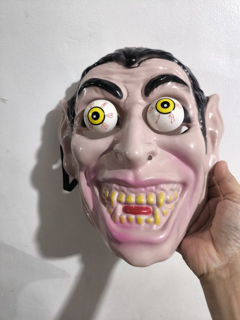 Scary Halloween Mask (Category: Other Merchandise) located in Marikina City. Submitted by alecfordy (Listing ID 1470627477, Image 1). Description: plastic horror mask with moving or bulging yellow-and-red-veined eyeballs, slick black hair, pointed ears, a wide grinning mouth with yellow teeth, and red lips.