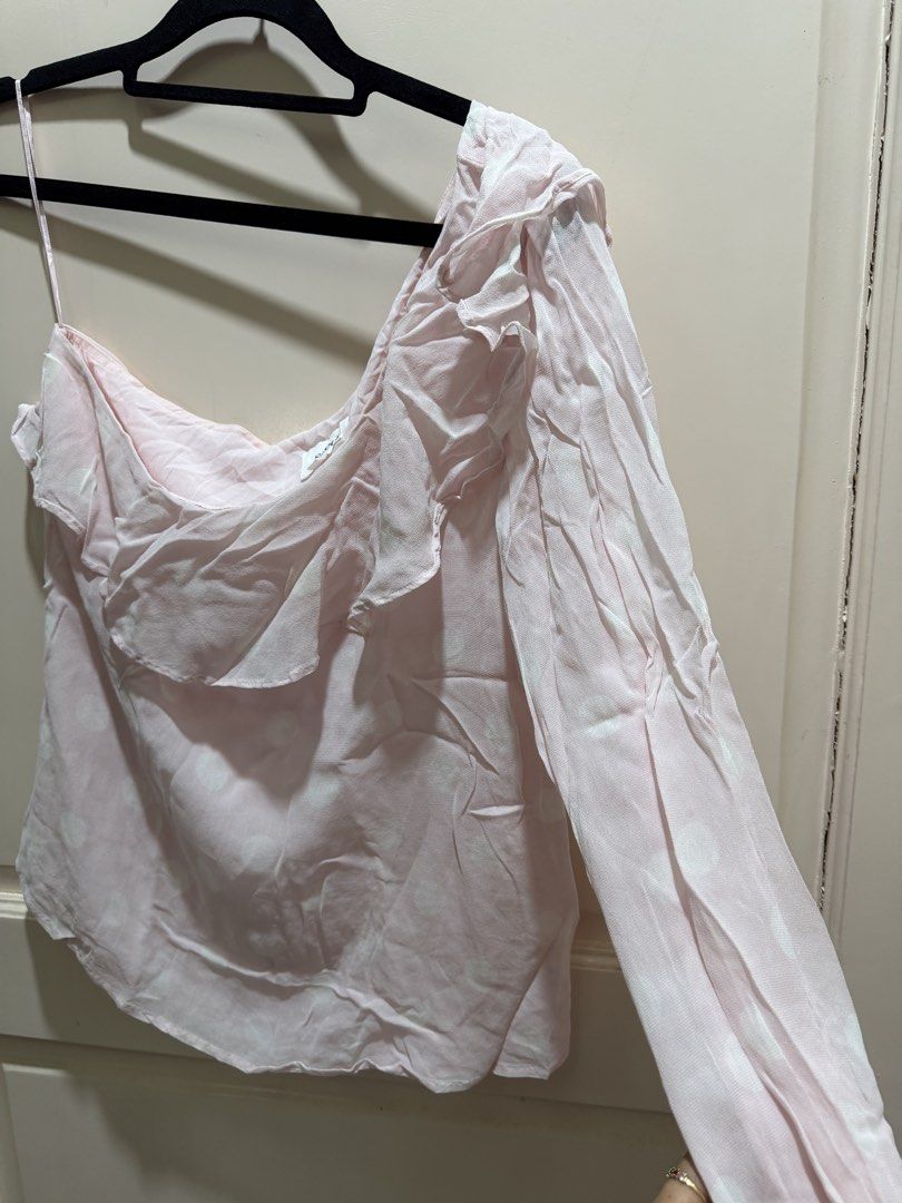 Seed Heritage Pink Polka Dot One-Shoulder Ruffle Blouse (Category: Blouses) located in Davao. Submitted by 2ndbase.dvo.ii (Listing ID 1470597307, Image 3). Description: - Brand: Seed Heritage - Color: Soft pink with white polka dots - Design: One-shoulder asymmetrical neckline with layered ruffle trim - Sleeves: Long balloon sleeve with comfortable elastic cuff - Material: Lightweight chiffon - Styling: Versatile piece, easy to pair with jeans or