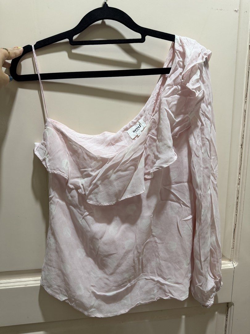 Seed Heritage Pink Polka Dot One-Shoulder Ruffle Blouse (Category: Blouses) located in Davao. Submitted by 2ndbase.dvo.ii (Listing ID 1470597307, Image 2). Description: - Brand: Seed Heritage - Color: Soft pink with white polka dots - Design: One-shoulder asymmetrical neckline with layered ruffle trim - Sleeves: Long balloon sleeve with comfortable elastic cuff - Material: Lightweight chiffon - Styling: Versatile piece, easy to pair with jeans or