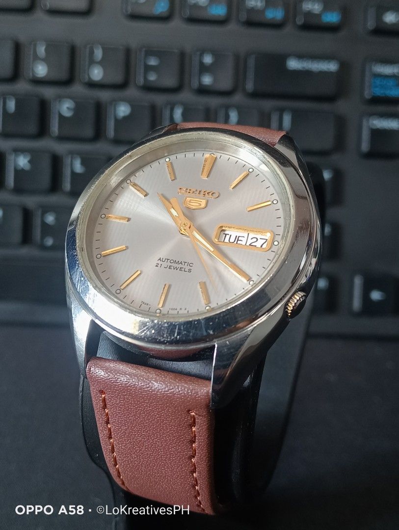 Seiko 5 SNKL19K1 (Category: Men's Watches) located in Cavite. Submitted by purpose_served (Listing ID 1470558883, Image 2). Description: Seiko 5 Automatic SNKL19K1 features a gray/silver sunburst dial with gold-tone indices and hands, a day-date display, a 21-jewel 7S26 automatic movement, Hardlex crystal, approximately 40-hour power reserve, 30-meter water resistance. Things to know: New aftermarket brown leather strap. Never opened or serviced.