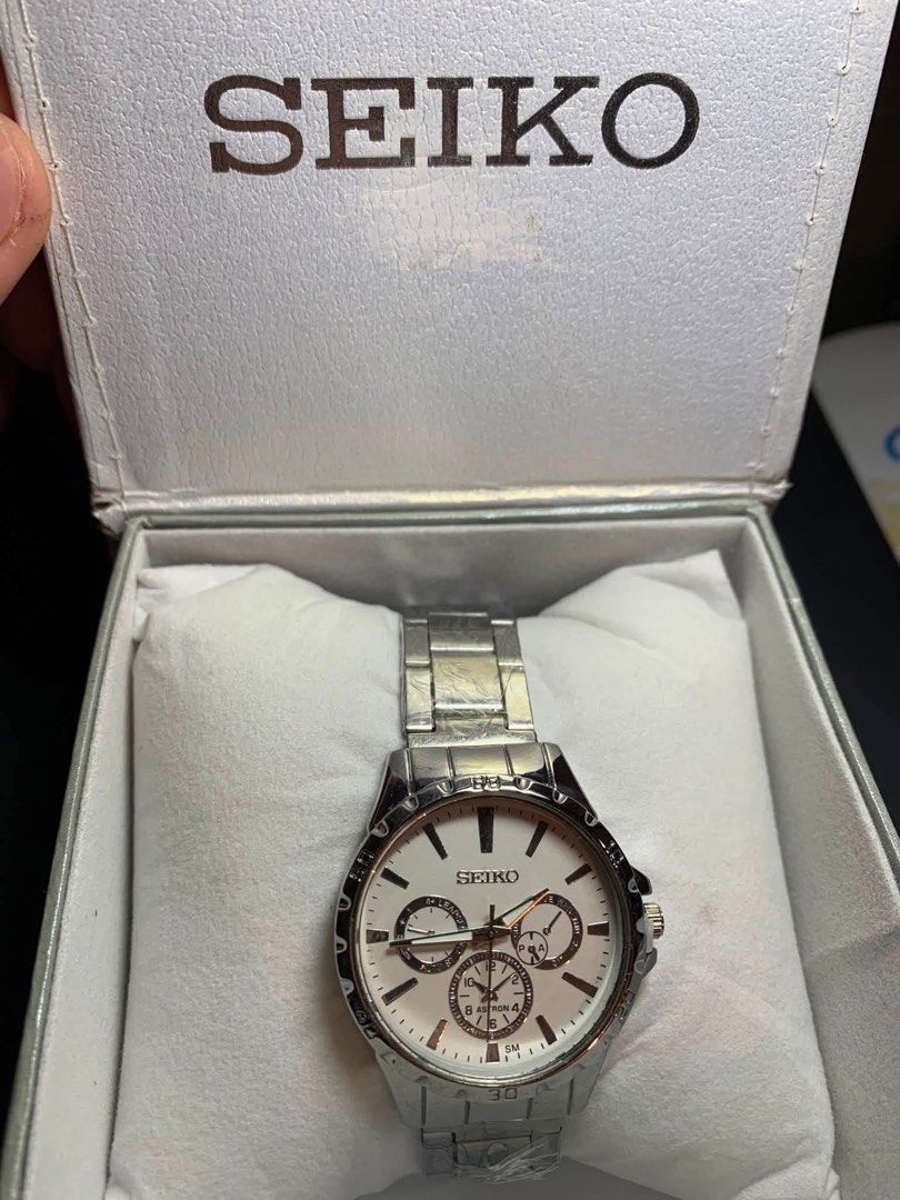 Seiko Chronograph Watch with Box (Category: Men's Watches) located in Manila. Submitted by vincyzz88 (Listing ID 1470618819, Image 1). Description: - not premium Seiko silver tone chronograph watch - White dial equipped with three functional sub-dials - Elegant rose gold hands and markers - Durable stainless steel bracelet strap - Includes original white branded presentation box with cushion pillow - Perfect for daily wear or special occasions - 