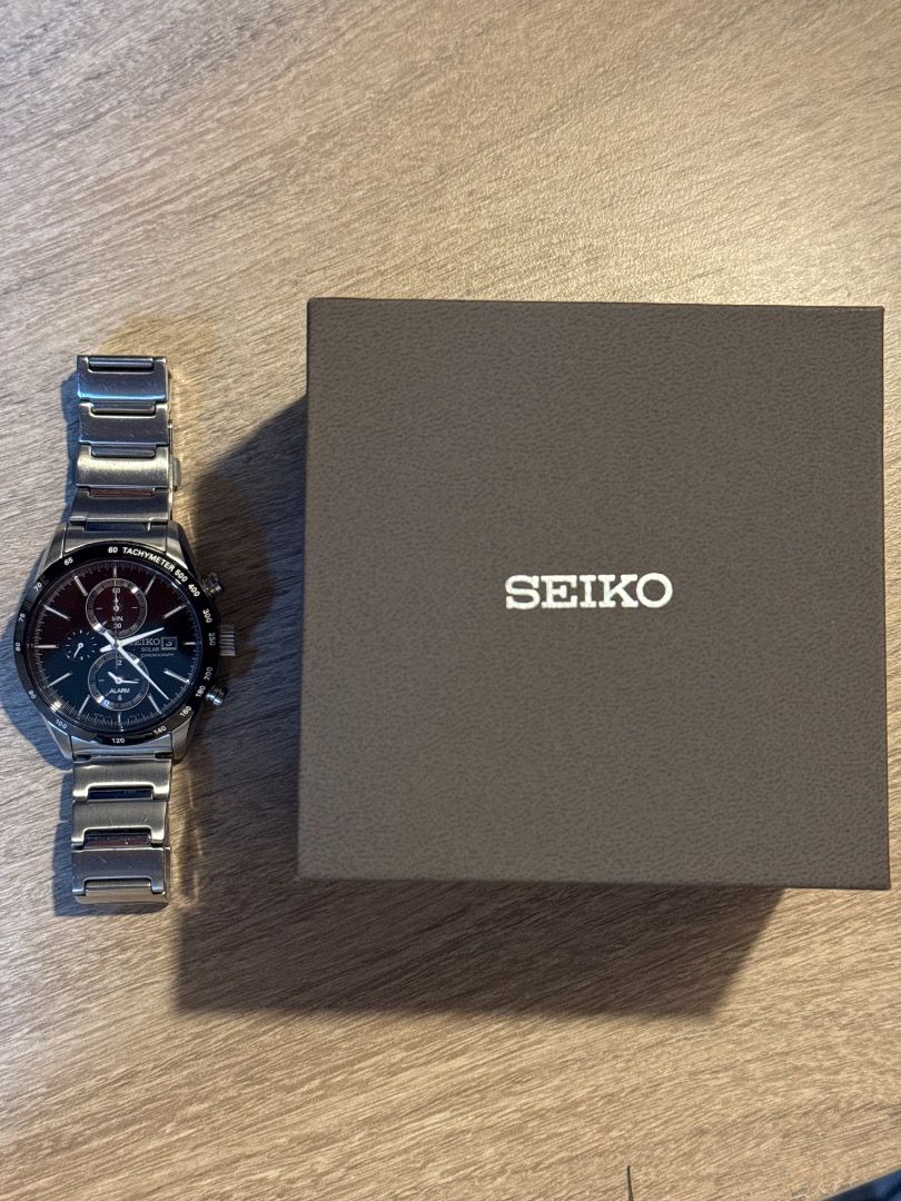 Seiko Solar Chronograph Watch with Original Box (Category: Men's Watches) located in Muntinlupa City. Submitted by keitho. (Listing ID 1470670993, Image 1). Description: - Brand: Seiko Solar Chronograph - Material: Stainless steel case and link bracelet - Dial: Dark dial with multiple sub-dials and tachymeter bezel - Power: Solar-powered (charges via light, no battery replacement needed) - Condition: Clean crystal, minor hairline marks on the met