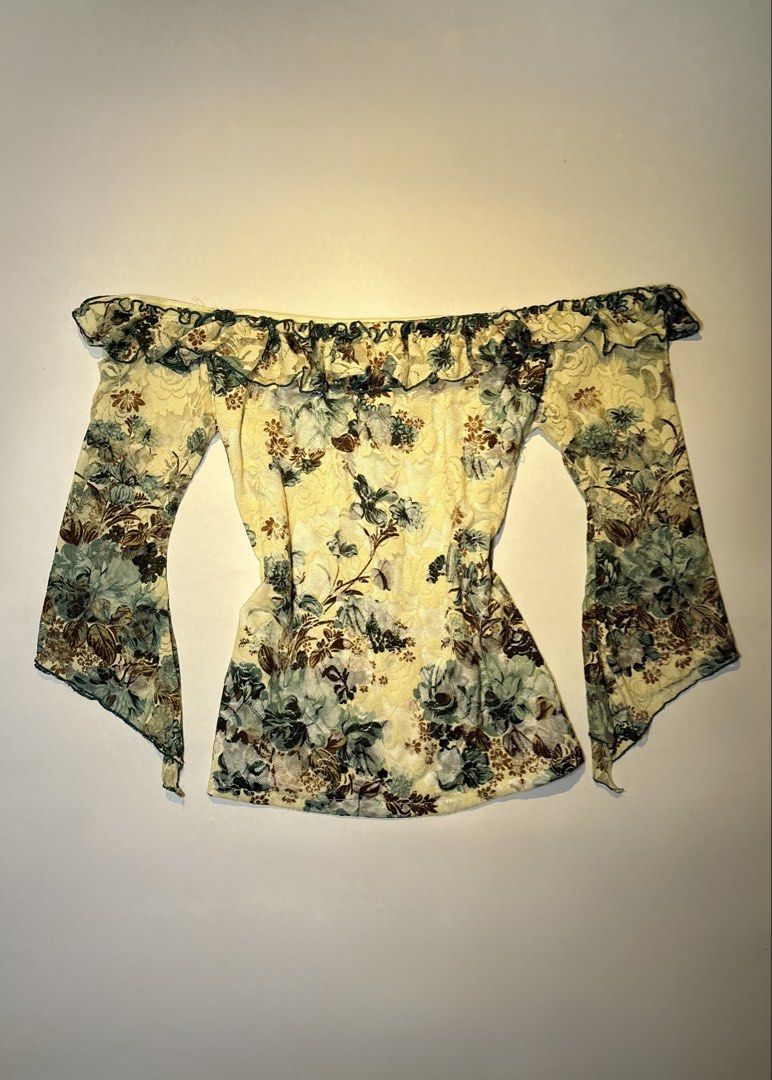 ShalyShow Off-Shoulder Floral Lace Top (Category: Blouses) located in Bacolod City. Submitted by thlnn_vls (Listing ID 1470702693, Image 1). Description: - Brand: Shaly - Style: Off-shoulder slim-fit top - Material: Stretchy mesh lace - Color/Print: Pale yellow with dark green and brown floral print - Details: Ruffled neckline and long bell sleeves with lettuce hem trim.