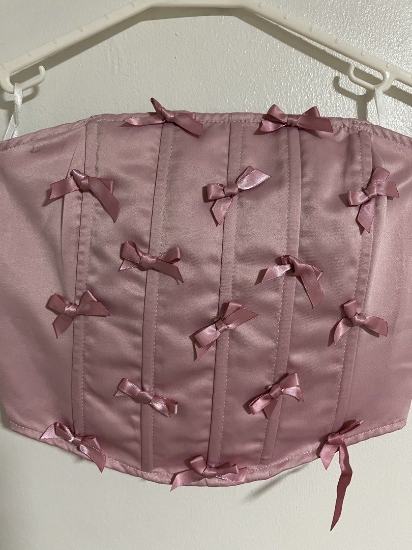 SHEIN Pink Bow Corset Crop Top (Category: Sleeveless) located in Cabuyao City. Submitted by rdtrmt (Listing ID 1470577131, Image 2). Description: - Brand: Shein - Style: Strapless tube corset crop top with boning - Design: Pink satin with all-over little bows - Fit: Smocked elastic back panel for easy stretch - Size: Small (US 4, EU 36) - Material: 100% polyester - Condition: still in good condition.
