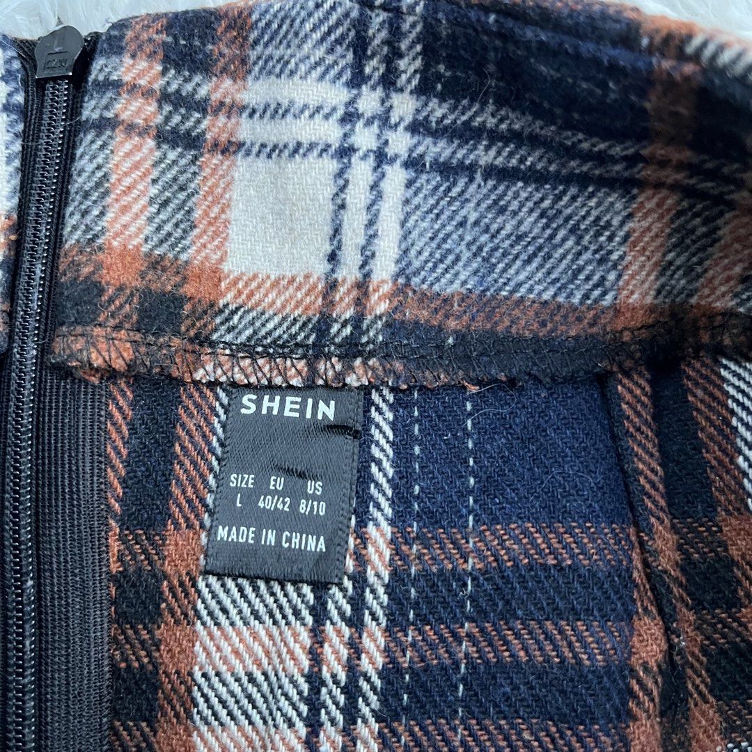 SHEIN Plaid Mini Skirt Size L (Category: Skirts) located in Cuyapo. Submitted by Ashtyn.Pre.Loved (Listing ID 1470739452, Image 2). Description: - Brand: Shein - Design: Plaid pattern in blue, brown, and white tones with double front slit details - Closure: Back zipper - Size: L / EU 40-42 / US 8-10 - Style Tip: Great for autumn outfits; easy to style with boots and sweaters.