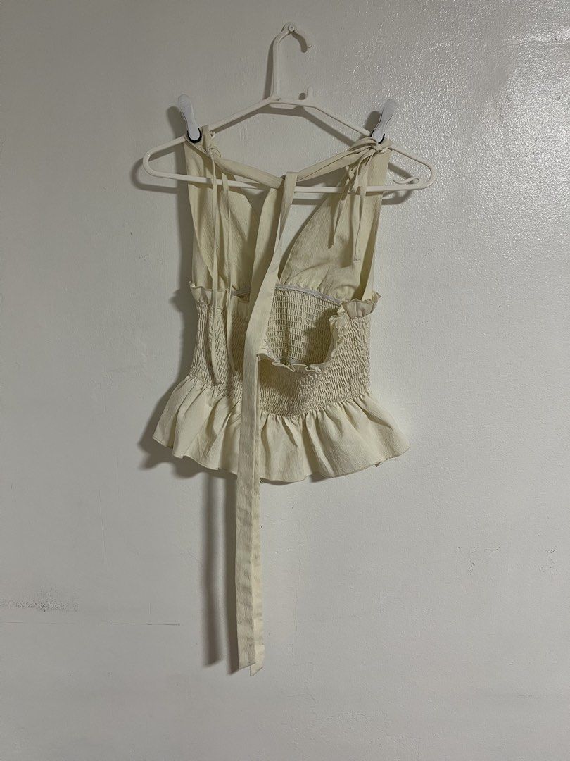 SHEIN White Smocked Ruffle Tie-Back Top (Category: Sleeveless) located in Cabuyao City. Submitted by rdtrmt (Listing ID 1470576483, Image 3). Description: - Brand: SHEIN - Color: Cream White - Size: XS (US 2, EU 34) - Design: Smocked bodice, deep V-neck front & back, with sweet ruffle hems - Straps: Adjustable tie straps for a custom fit - Material: 97% polyester, 3% elastane (machine washable) - Condition: still in good condition .