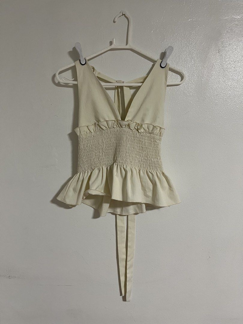 SHEIN White Smocked Ruffle Tie-Back Top (Category: Sleeveless) located in Cabuyao City. Submitted by rdtrmt (Listing ID 1470576483, Image 1). Description: - Brand: SHEIN - Color: Cream White - Size: XS (US 2, EU 34) - Design: Smocked bodice, deep V-neck front & back, with sweet ruffle hems - Straps: Adjustable tie straps for a custom fit - Material: 97% polyester, 3% elastane (machine washable) - Condition: still in good condition .