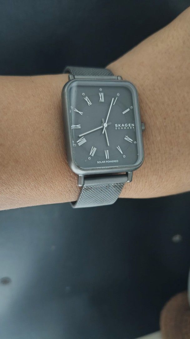 Skagen Denmark Solar Powered Rectangular Watch (Category: Men's Watches) located in Taguig. Submitted by mercyeugen28914 (Listing ID 1470679437, Image 2). Description: - Brand: Skagen Denmark - Dial: Dark grey rectangular dial with classic Roman numerals - Strap: Gunmetal grey mesh strap with a fully adjustable clasp - Design: Sleek, minimalist, and versatile - Condition: Worn a few times; minor hairline scratches on the case back, while the crys