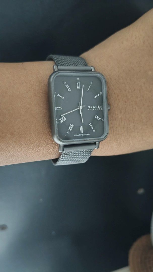 Skagen Denmark Solar Powered Rectangular Watch (Category: Men's Watches) located in Taguig. Submitted by mercyeugen28914 (Listing ID 1470679437, Image 3). Description: - Brand: Skagen Denmark - Dial: Dark grey rectangular dial with classic Roman numerals - Strap: Gunmetal grey mesh strap with a fully adjustable clasp - Design: Sleek, minimalist, and versatile - Condition: Worn a few times; minor hairline scratches on the case back, while the crys