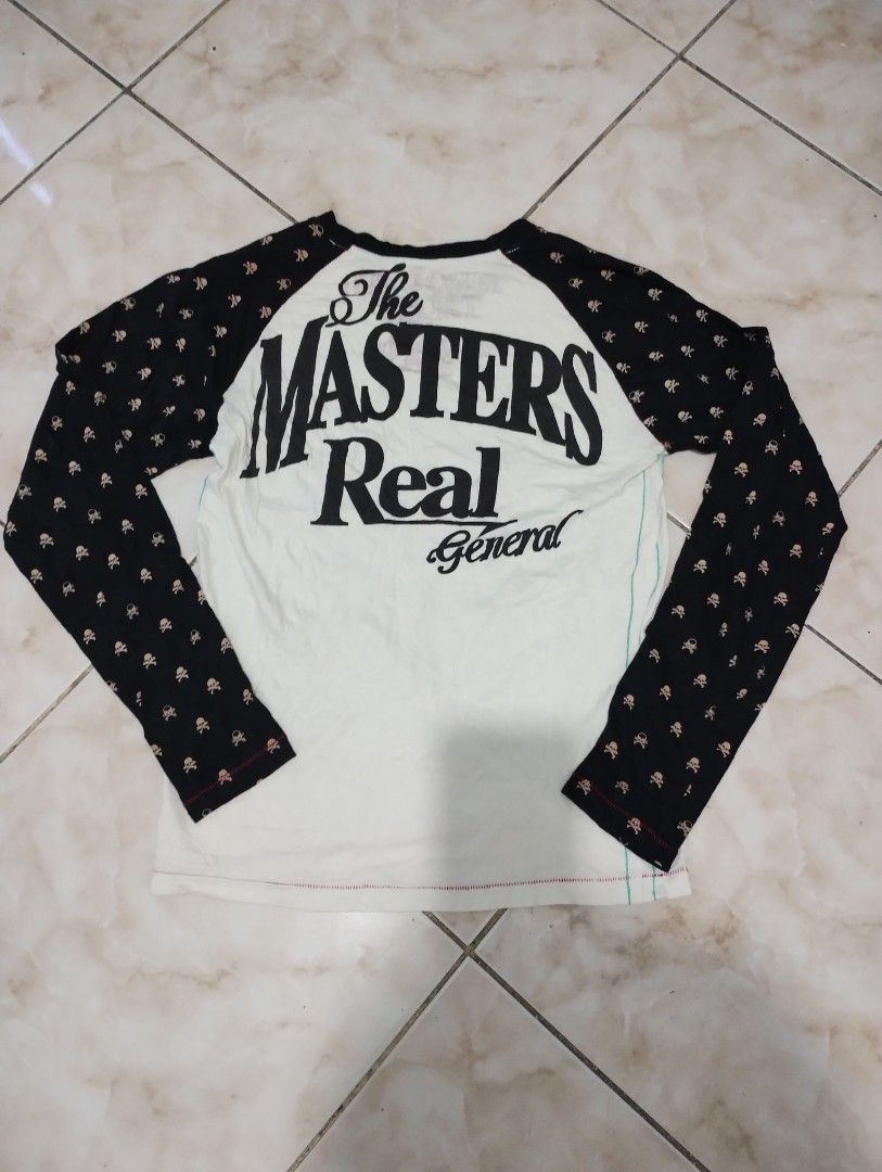 Skull Print Raglan Long Sleeve Shirt (Category: Longsleeves) located in Imus. Submitted by darylg88358770 (Listing ID 1470646347, Image 2). Description: - Color/Design: Black and white raglan with all-over skull pattern sleeves and bold front graphic - Back Details: Large "THE MASTERS Real General" print - Size: Medium (M) as per tag - Condition: Pre-owned with some visible discoloration stains on the front white fabric the items trifted fresh fr