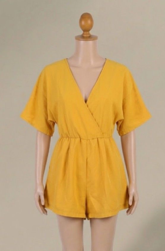 Something Borrowed Surplice V-Neck Short Romper (Category: Rompers) located in Quezon City. Submitted by dannikkishoppe2 (Listing ID 1470680650, Image 1). Description: Something Borrowed Surplice V-Neck Short Romper ‼️₱400‼️ • Color: Mustard Yellow / Golden Yellow • Neckline: Deep V-neck with a faux-wrap (surplice) front • Sleeves: Relaxed, loose kimono-style short sleeves • Legs: Relaxed, wide-leg shorts • Closure: Back zipper closure • Worn onc