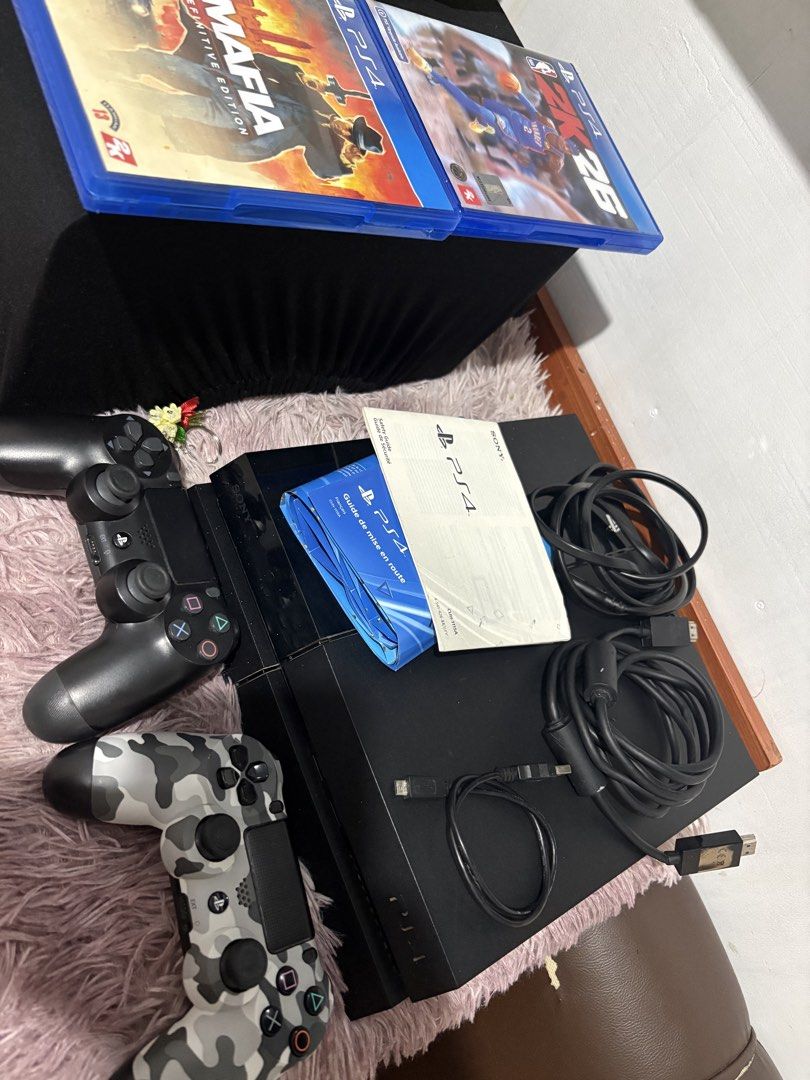 Sony PlayStation 4 Console with 2 Controllers and Games (Category: PlayStation) located in Makati City. Submitted by wpglyn (Listing ID 1470579293, Image 2). Description: Original 2 controllers Original HDMI cable Original Power cable Usb charging cable PS4 Manual and booklets 2k26 game Disc Mafia definitive edition game Disc Issue black controller not working. Rfs may Ps5 na.