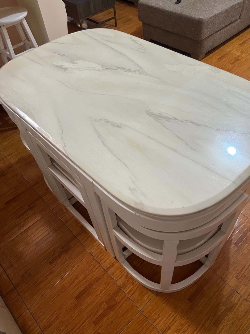 Space-saving Dining Table with 4 Nesting Chairs White Marble Top (Category: Tables & Sets) located in Pasay City. Submitted by daisuki.x0x0 (Listing ID 1470655709, Image 1). Description: - Elegant white marble pattern tabletop - Includes 4 matching chairs that tuck neatly underneath to save floor space - Glossy white wooden frames with solid, sturdy construction - Clean surfaces all around, ideal for compact kitchens and dining areas - Condition: