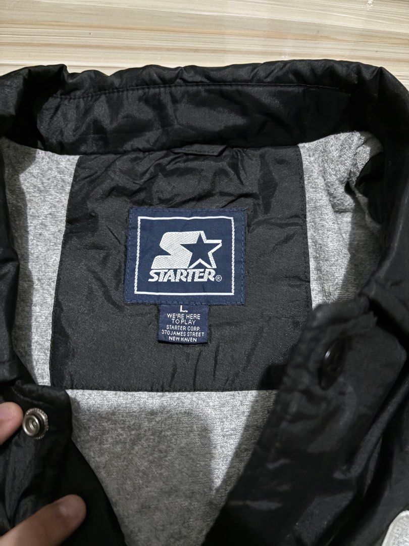 Starter Vintage Black Nylon Coach Jacket Size L (Category: Coats, Jackets and Outerwear) located in Ajuy. Submitted by reeyn0515 (Listing ID 1470708588, Image 3). Description: -25x29 - Brand: Starter Corp - Color: Solid black - Size: Large (L) - Design: Large embroidered logo patch on chest and oversized logo on the back - Features: Snap button front, collar, and adjustable drawstring hem - Lining: Grey jersey cotton lining for added warmth.