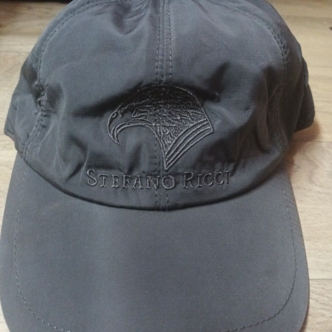 Stefano Ricci Grey Cap (Category: Caps & Hats) located in Manila. Submitted by itsnik444 (Listing ID 1470634783, Image 2). Description: - Brand: Stefano Ricci - Color: Dark grey with grey heather lining and orange inner trim - Design: Embroidered eagle logo and brand name on the front - Fit: Adjustable elastic back strap for a secure fit - Origin: Made in Italy - Care: Machine washable.