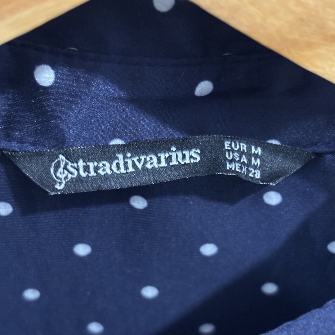 Stradivarius Navy Blue Polka Dot Long Sleeve Button-Down Shirt (Category: Longsleeves) located in Makati City. Submitted by trustmebuythis (Listing ID 1470713263, Image 3). Description: - Color & Pattern: Navy blue with all-over white polka dots - Fit: Relaxed, slightly oversized with a curved hem - Material: Smooth, super soft satin-like fabric - Details: Classic collar, long sleeves, and front button closure - Size: Medium (EUR, USA, and MEX si