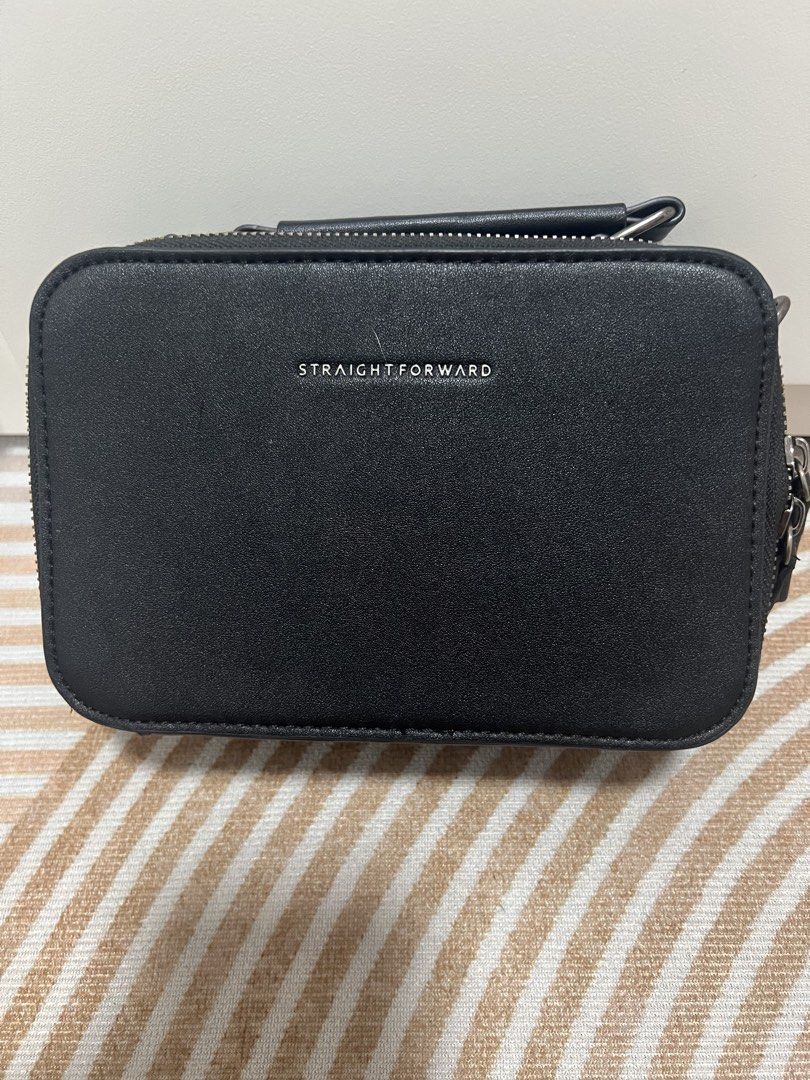 Straightforward Black Sling Bag with Strap (Category: Sling Bags) located in Manila. Submitted by luckymike059973 (Listing ID 1470562960, Image 2). Description: - Brand: Straightforward - Style: Black camera-style sling bag - Details: Branded silver lettering on the front - Storage: Main zip compartment and quick-access back slip pocket for cards - Strap: Thick adjustable strap with printed logo detail on the shoulder pad - Condition: Clean inter