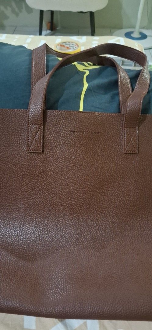 Straightforward Brown Leather Tote Bag (Category: Tote Bags) located in Paranaque City. Submitted by finders_thriftersph (Listing ID 1470675180, Image 1). Description: - Material: Premium brown pebbled leather with deep maroon suede interior - Straps: Comfortable dual shoulder straps with clean stitching - Closure: Secure magnetic main snap closure - Storage: Convenient inner pocket with magnetic button closure - Style: Simple, structured design 