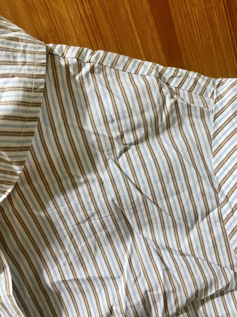 Striped Short Sleeve Button-Up Shirt (Category: Shirts) located in Angono. Submitted by carefree03 (Listing ID 1470724957, Image 2). Description: - Design: Brown and light blue vertical stripes - Fit: Standard fit, great for pairing with jeans or skirts - Comfort: Lightweight fabric, ideal for warm weather - Details: Classic collar and single chest pocket with embroidery - Condition: Brand new / Excellent quality.
