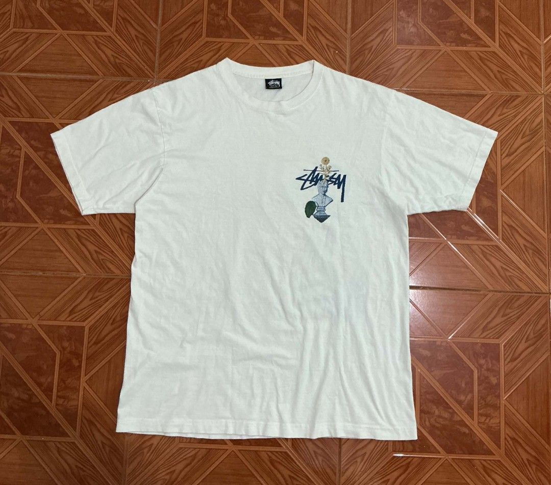 Stussy Graphic Tee White (Category: Tshirts & Polo Shirts ) located in Manila. Submitted by janbrix (Listing ID 1470605848, Image 1). Description: - Brand: Stussy - Color: Classic White - Fit: Regular fit, standard streetwear tee - Design: Small front chest pocket print & large surreal back collage graphic (cacti, birds, flowers, typography) - Details: Short sleeves, crew neck - Condition: Excellent pre-loved condition - Shipping: Ships fast from