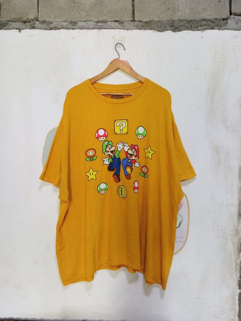 Super Mario Graphic Tee Yellow Size 4XL (Category: Tshirts & Polo Shirts ) located in Magdalena. Submitted by magdalenathrift20 (Listing ID 1470671868, Image 2). Description: - Official 2023 Nintendo Super Mario merchandise - Bright yellow tee with classic Mario, Luigi, and power-up graphics - Tagged Size: 4XL - Measurements: 31 inches chest width, 32.5 inches length - Relaxed fit and super comfy cotton material.