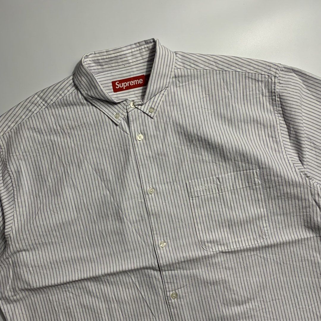 Supreme Striped Short Sleeve Button Down Shirt Size L (Category: Luxury Apparel) located in Dagupan City. Submitted by source_ph (Listing ID 1470685224, Image 2). Description: Size: XL mens ‎Width : 28 ‎Length: 33 ‎Shoulder: 22 ‎Sleeves: 12 - Brand: Supreme - Style: Short sleeve button-down shirt - Color/Pattern: White base with fine blue and red vertical stripes - Details: Button-down collar, front chest pocket with embroidered Supreme logo, red