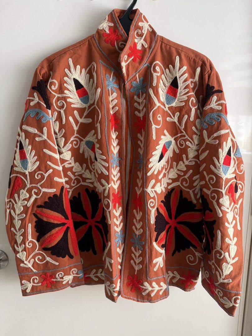 Suzani Jacket Cotton Embroidered Rust Color reversible (Category: Coats, Jackets and Outerwear) located in Las Pinas. Submitted by katrt (Listing ID 1470596445, Image 1). Description: - Brand: Asian Emporium - Condition: Brand new with tags attached - Color: Rust orange with striking white, black, red, and blue floral embroidery - Design: Open front style with a chic high collar and striped inner lining - Measurements: ~23 inches pit to pit, ~25 