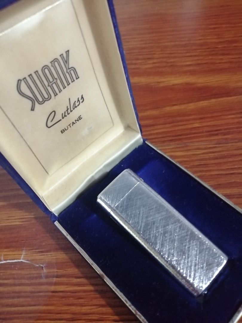 SWANK Cutlass Butane Lighter in Original Box as is (Category: Vintage Collectibles) located in Caloocan City. Submitted by jeicee858582831 (Listing ID 1470595123, Image 1). Description: - Vintage SWANK Cutlass butane lighter - Silver-tone textured finish body - Engraved with SWANK and U.S. Patent No. 319297 - Comes with original dark blue presentation box and cream satin lining - Excellent find for collectors.