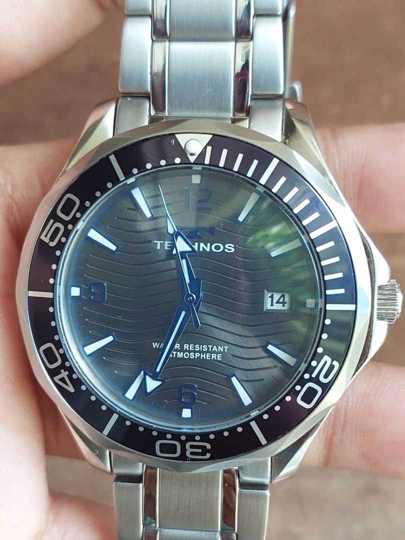 Technos T9B98 Stainless Steel Diver Watch (Category: Men's Watches) located in Batangas. Submitted by vintageanddainty (Listing ID 1470581263, Image 2). Description: - Brand/Model: Technos T9B98 Dive Watch - Movement: Battery-powered quartz movement, keeping great time - Dial: Textured grey-blue with wave pattern, silver hands, and date window at 3 o'clock - Bezel: Dark blue rotating bezel with contrasting markers - Build: Stainless steel case an
