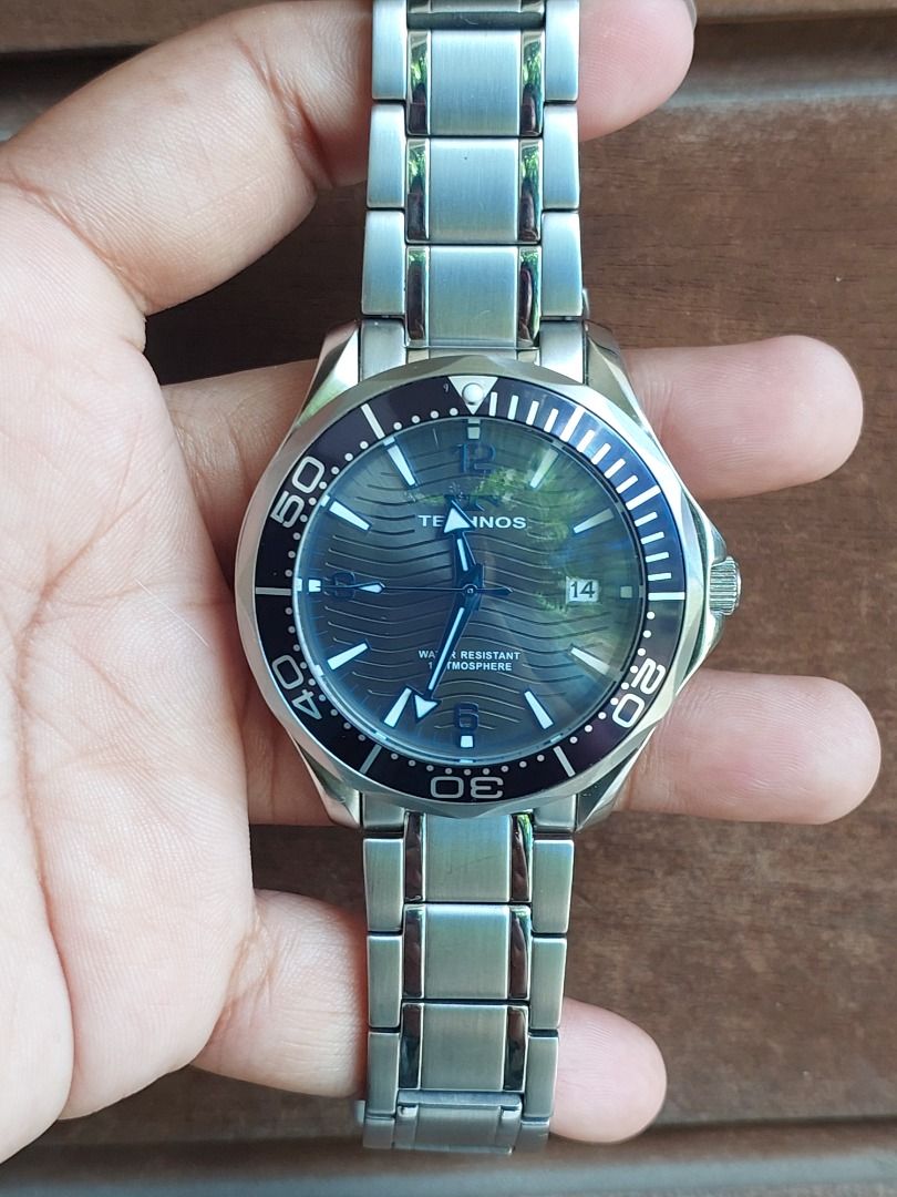 Technos T9B98 Stainless Steel Diver Watch (Category: Men's Watches) located in Batangas. Submitted by vintageanddainty (Listing ID 1470581263, Image 1). Description: - Brand/Model: Technos T9B98 Dive Watch - Movement: Battery-powered quartz movement, keeping great time - Dial: Textured grey-blue with wave pattern, silver hands, and date window at 3 o'clock - Bezel: Dark blue rotating bezel with contrasting markers - Build: Stainless steel case an
