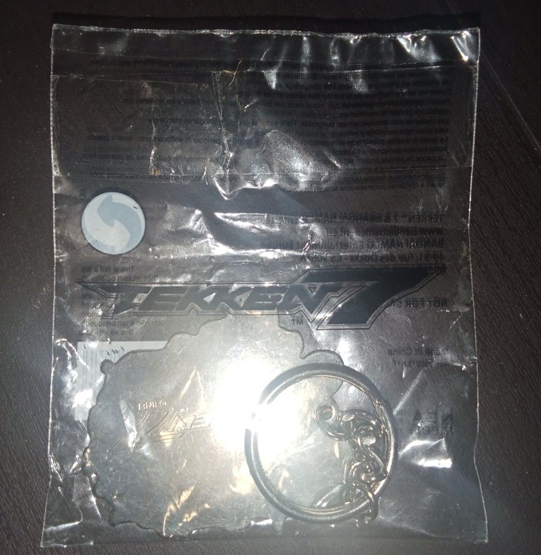 Tekken 7 Yoshimitsu Official Keychain (Category: Character Goods) located in Cavite. Submitted by emilgarcia09 (Listing ID 1470729535, Image 2). Description: - Official Bandai Namco Tekken 7 merchandise - Character: Yoshimitsu - Condition: Brand new, still sealed in original plastic packaging with barcode sticker - Design: Detailed artwork on the front with classic logo on the reverse - Hardware: Includes metal split ring, ready for keys or bags.