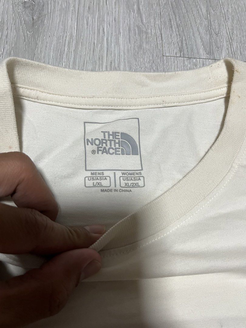 The North Face Never Stop Exploring Graphic T-Shirt (Category: Tshirts & Polo Shirts ) located in Manila. Submitted by jorgemabelin2001 (Listing ID 1470697955, Image 3). Description: - Brand: The North Face - Color: Off-white - Material: 100% Cotton - Design: Small red chest logo, large geometric tent graphic and 'Never Stop Exploring' text on the back - Size: Men US L / Asia XL | Women US XL / Asia 2XL - Made in: China - Flaws: Noticeable yellow