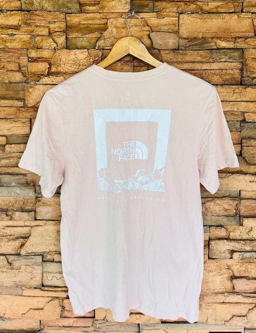 The North Face Pink T-Shirt (Category: Activewear) located in Santiago. Submitted by reyibanez253969 (Listing ID 1470702695, Image 2). Description: - Authentic The North Face pink t-shirt - Size: S-M - 19x26 - Short sleeves with a classic crew neck - Small white logo printed on the left chest - Large back graphic with mountain artwork and 'Never Stop Exploring' phrase - Includes holographic authenticity tag inside the collar - Comfortable regular