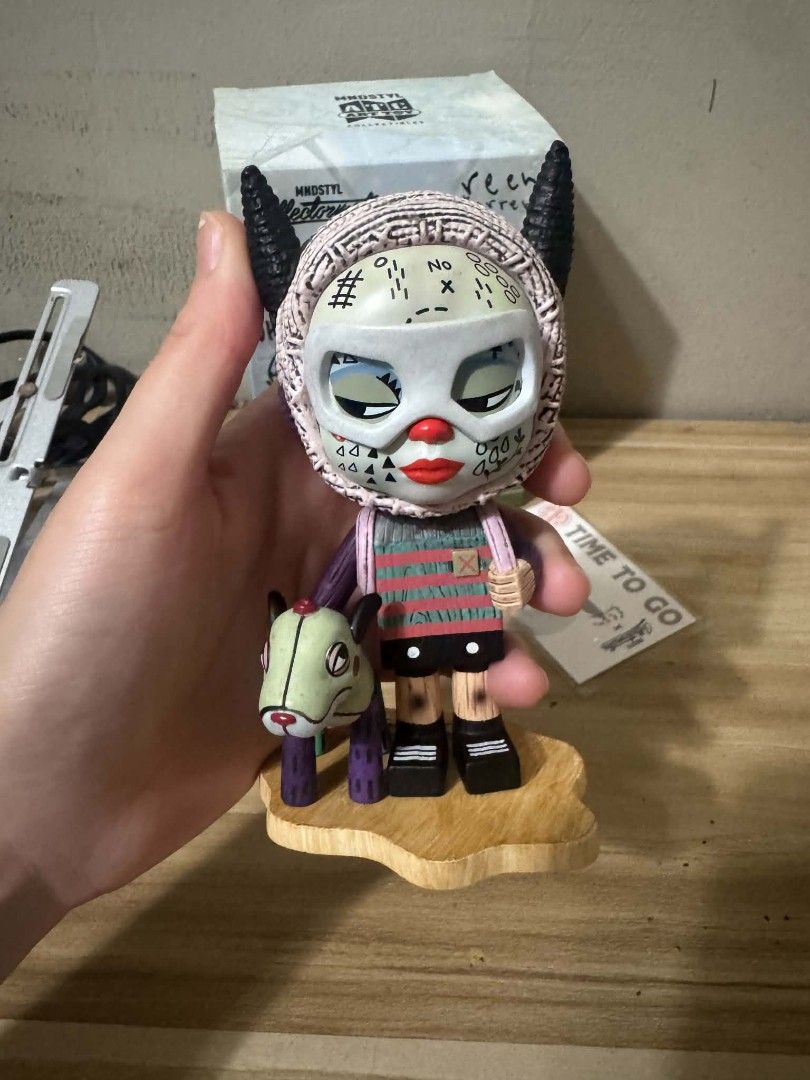 Time To Go Reen Barrera Vinyl Figure (Category: Designer & Blind Box Toys) located in San Juan City. Submitted by msmpatron (Listing ID 1470564584, Image 2). Description: - Brand/Artist: MNDSTYL Collectormates x Reen Barrera - Title: Time To Go designer art toy - Design details: Knit hood with black horns, face tattoos, holding a toy dog, and wearing a backpack - Inclusions: Original box, signed artwork card, and wooden display base - Authenticit