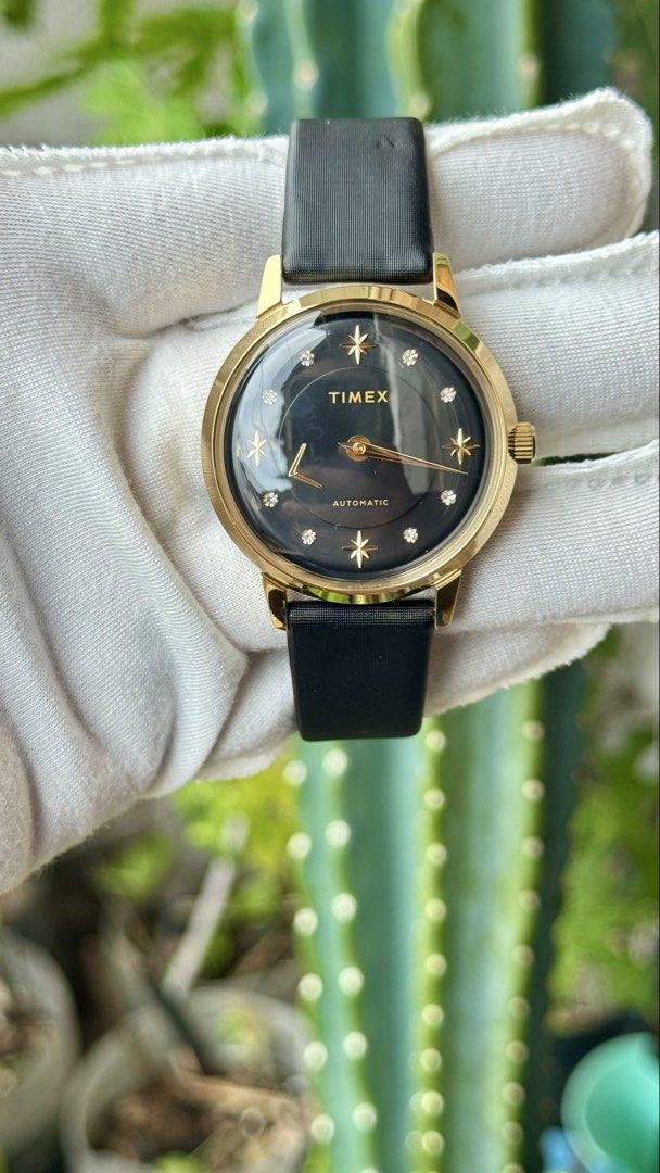 Timex Automatic Watch Gold Black Star Dial (Category: Luxury Watches) located in Manila. Submitted by junjun12356 (Listing ID 1470558443, Image 1). Description: - Brand: Timex - Movement: Automatic - Case: Gold-tone with a domed crystal - Dial: Black with star and crystal hour markers, and gold hands - Strap: Black textured leather strap - Condition: Clean overall with minimal signs of wear.