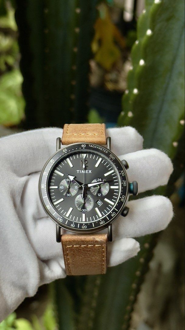 Timex Chronograph Watch with Leather Strap (Category: Men's Watches) located in Manila. Submitted by junjun12356 (Listing ID 1470557898, Image 1). Description: Timex chronograph watch featuring a dark grey dial and tachymeter bezel. Brown leather strap with contrast stitching and buckle closure. Sub-dials track minutes and seconds, plus a date window at the four o'clock position. White hands and hour markers stand out clearly against the face. Ma