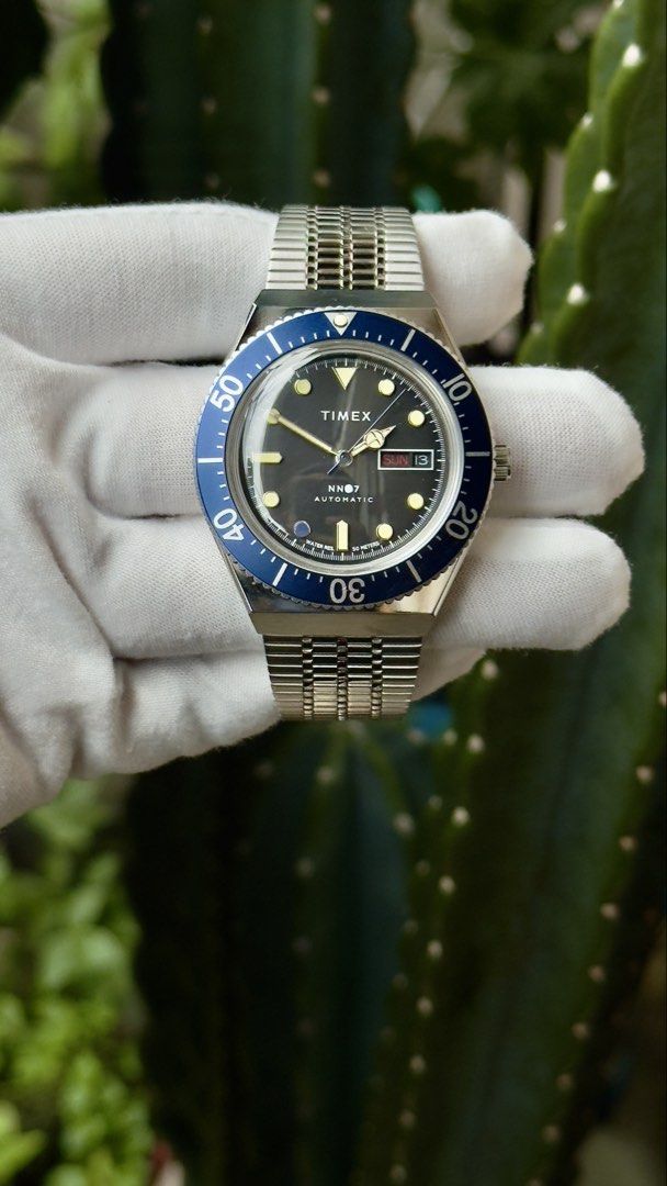 Timex NN07 Automatic Blue Bezel Watch BATMAN (Category: Men's Watches) located in Manila. Submitted by junjun12356 (Listing ID 1470557825, Image 1). Description: - Brand/Collab: Timex x NN07 Automatic Watch - Dial: Dark dial with day and date window at 3 o'clock - Bezel: Blue rotating bezel with white markers - Strap: Steel bracelet with adjustable clasp and 'T' logo crown - Condition: Worn a few times, minimal signs of wear on case and bracelet.