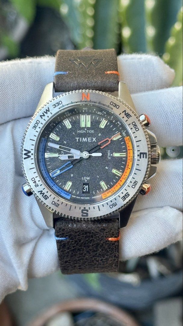 Timex Tide Temperature Compass Watch (Category: Men's Watches) located in Manila. Submitted by junjun12356 (Listing ID 1470702415, Image 1). Description: - Brand: Timex - Model: Tide Temperature Compass - Material: Stainless steel case with dark brown leather strap (featuring cool blue and orange accent stitching) - Dial: Textured black dial with date window at 6 o'clock and Indiglo night-light - Bezel: Rotational compass bezel with cardinal dire