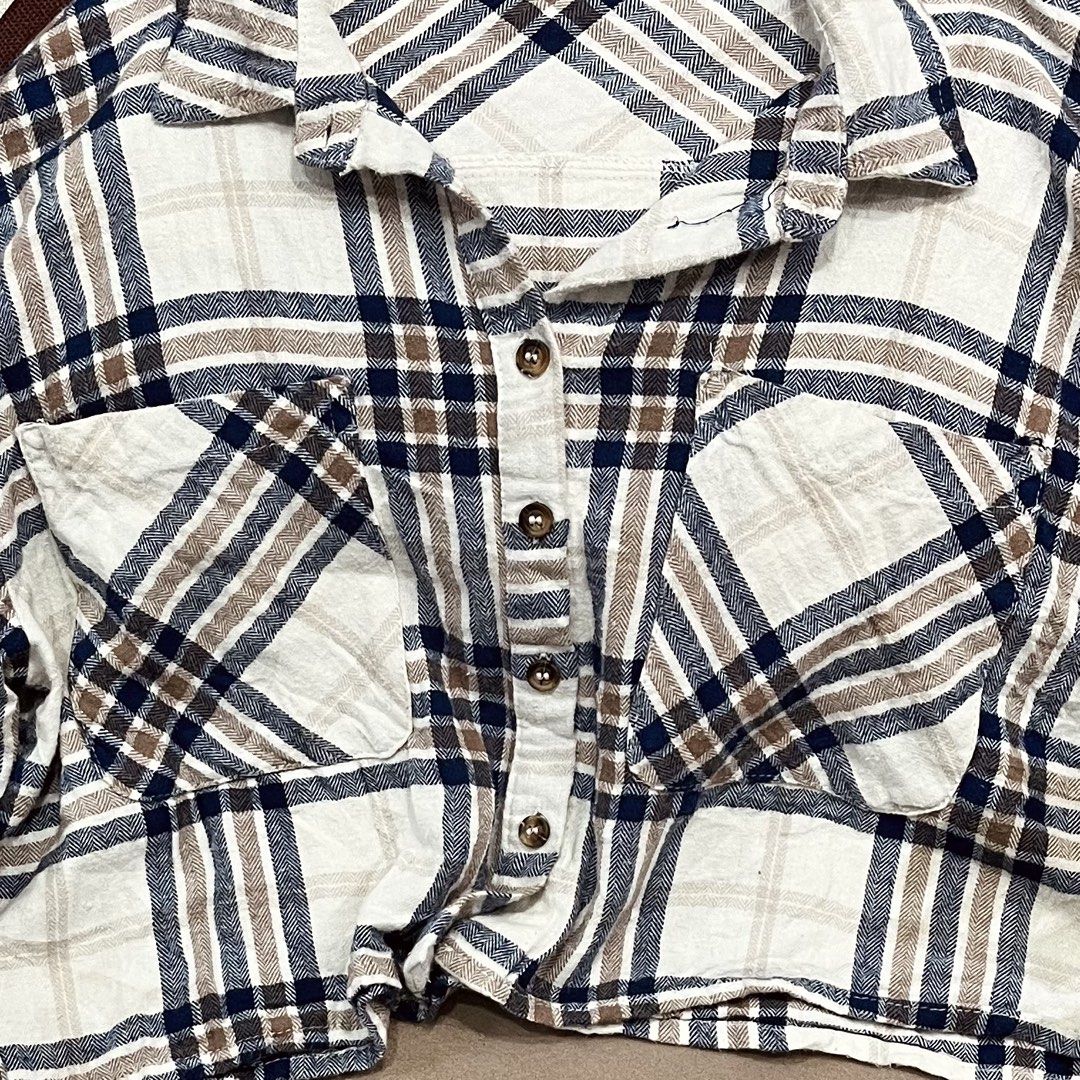 Timing Plaid Crop Button-Down Shirt (Category: Shirts) located in Manila. Submitted by mjsappstopandshop (Listing ID 1470694598, Image 2). Description: - Style: Casual flannel crop top - Color: Navy blue, brown, and off-white plaid - Details: Button-down front, collared neckline, and two chest pockets - Sleeves: Long sleeves with button cuffs - Fit: Cropped length, looks great with high-waisted jeans.