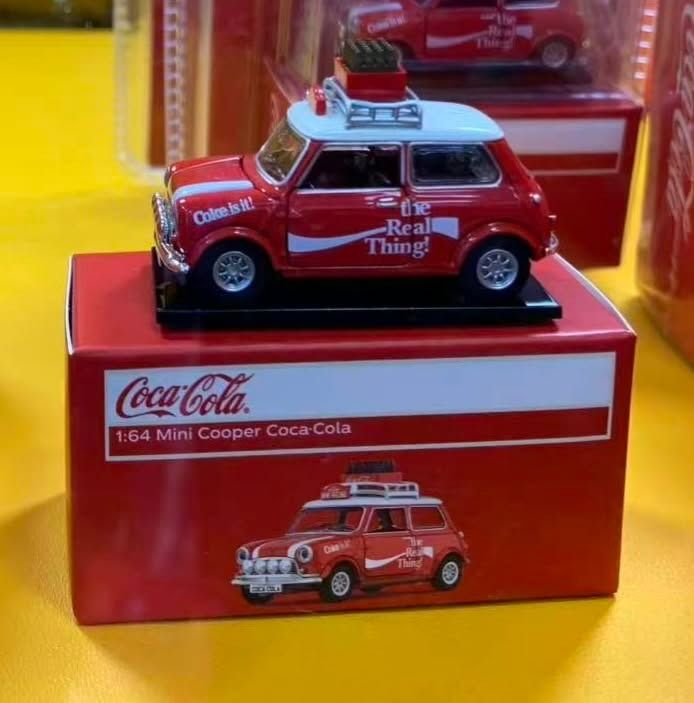 Tiny EXCLUSIVE! 1:64 Mini Cooper Coca-Cola Diecast Model Car (Category: Vehicle & Diecast Models) located in Tagaytay City. Submitted by gracey332 (Listing ID 1470672170, Image 1). Description: - Brand: Tiny - Scale: 1:64 - Model: Mini Cooper with Coca-Cola livery ("The Real Thing!" branding) - Colorway: Red body with white roof and roof rack - Condition: Brand new, unopened blister packaging inside a red display box - Ideal for die-cast collecto