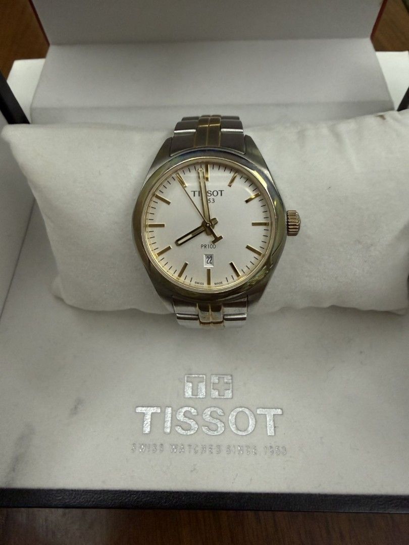 Tissot PR 100 Two-Tone Watch with Box (Category: Luxury Watches) located in Manila. Submitted by anythingbyjen (Listing ID 1470607691, Image 1). Description: - Authentic Tissot PR 100 wristwatch - Two-tone stainless steel and gold finish - Classic white dial with gold hands, index markers, and 6 o'clock date window - Secure folding clasp closure with iconic T logo - Includes original red and black Tissot presentation box - Condition: Shows visibl